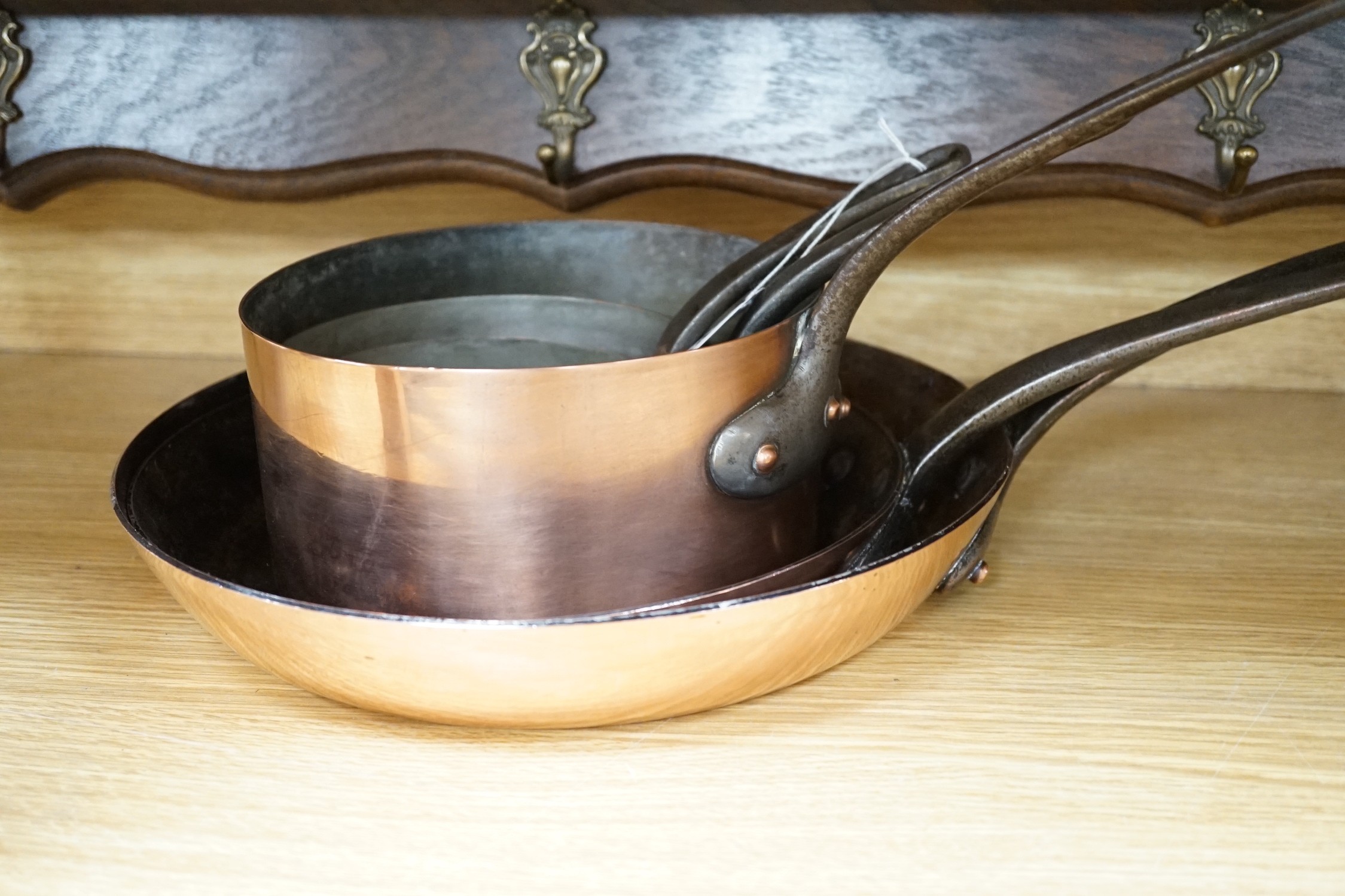 Two copper frying pans by Yves Gautier in Villedieu and three saucepans with an oak 5 hook pan rack